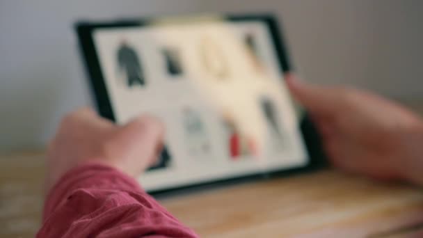 tablet w rękach człowieka, zakupy ubrania online - Materiał filmowy, wideo