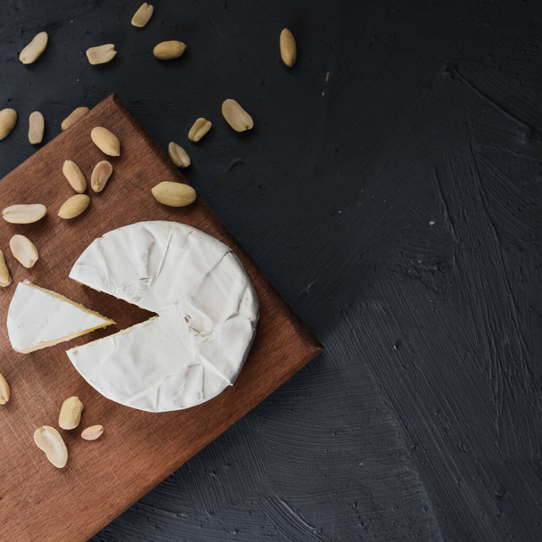 camembert fromage avec moule et noix sur planche en bois - Photo, image