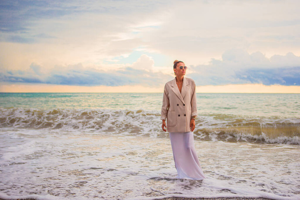 Γυναίκα στην παραλία απολαμβάνοντας τις καλοκαιρινές διακοπές - Φωτογραφία, εικόνα