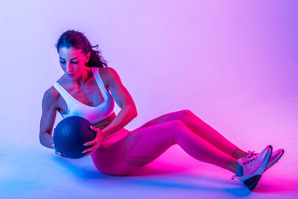 Athletic woman with fitness sportswear traning - Beautiful girl doing fitness in a studio - Foto, immagini