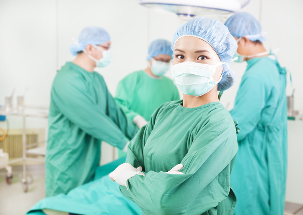 Cirurgião em pé na frente de um colega em uma sala cirúrgica
 - Foto, Imagem