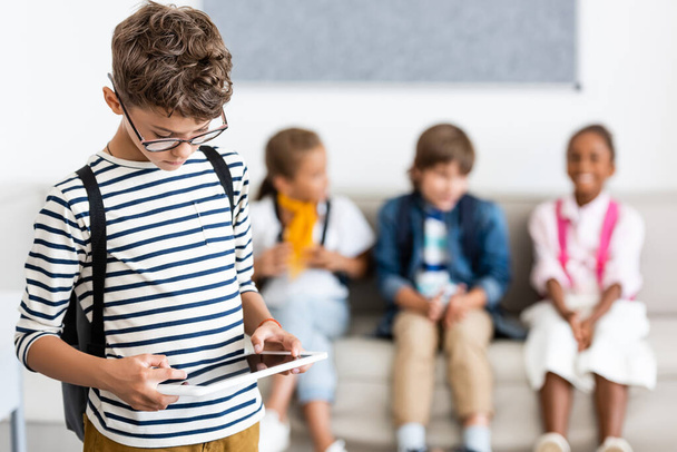 A digitális tabletet használó iskolás fiú szelektív fókusza az osztályteremben  - Fotó, kép