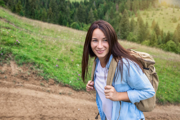Onnellinen nuori nainen turisti kävelee reppu ylängöllä. Aktiivisen elämäntavan käsite - Valokuva, kuva