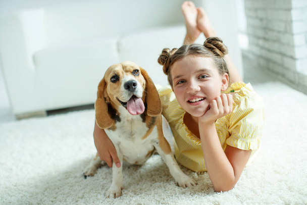 Dziecko z psem. nastolatka dziewczyna z a beagle pies w domu.  - Zdjęcie, obraz