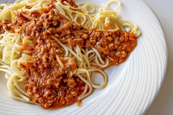 zbliżenie spaghetti z sosem na białym talerzu - Zdjęcie, obraz