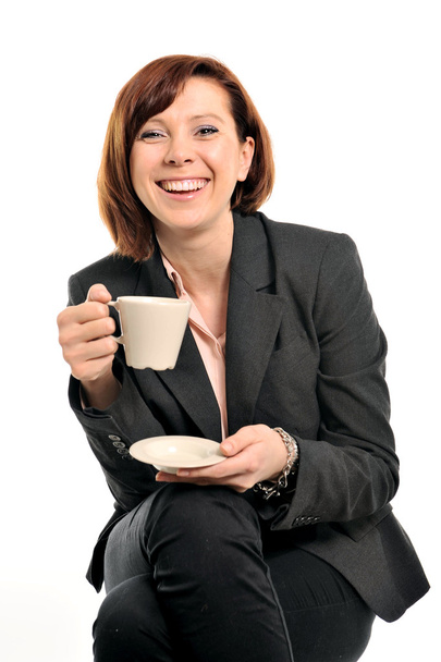 Happy business woman with red hair drinking coffee and smiling - Photo, Image