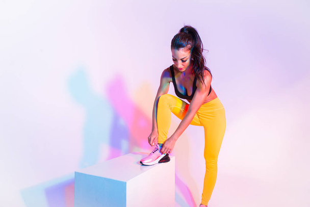Athletic woman with fitness sportswear traning - Beautiful girl doing fitness in a studio - Fotoğraf, Görsel
