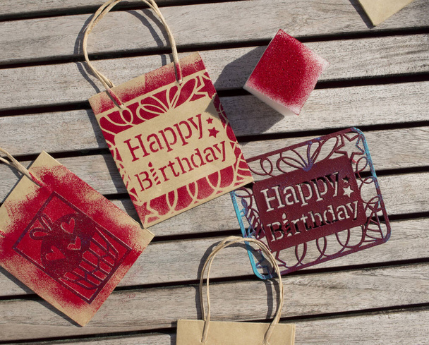 craft to give on a birthday. Stamping with template on paper bags. - Photo, Image