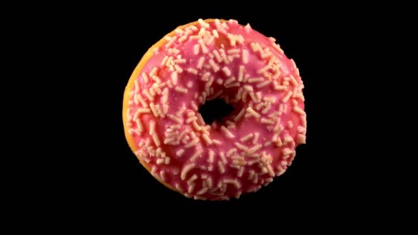 Fliegender rosa glasierter Donut mit Streusel. - Filmmaterial, Video