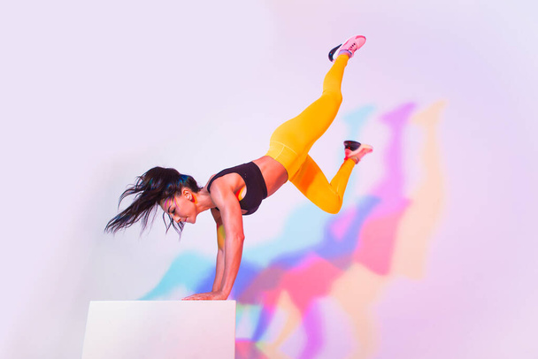 Athletic woman with fitness sportswear traning - Beautiful girl doing fitness in a studio - Valokuva, kuva