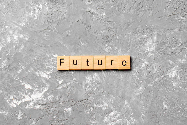 Palabra futura escrita en madera. Futuro texto sobre mesa de cemento para su diseño, concepto. - Foto, imagen