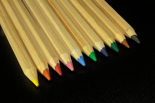 Дерев'яні барвисті звичайні олівці ізольовані на темному тлі. Освітнє обладнання
 - Фото, зображення
