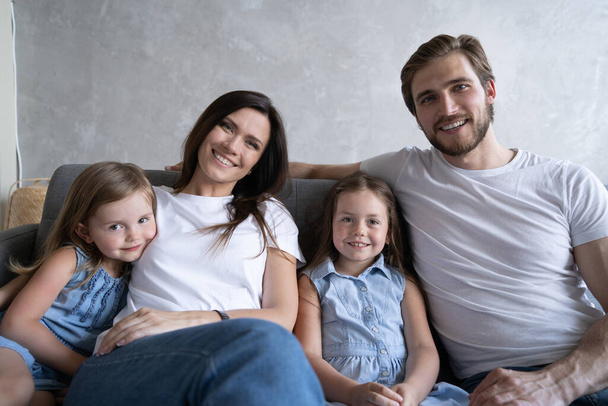 Cheerful family at home sitting in sofa. - Zdjęcie, obraz