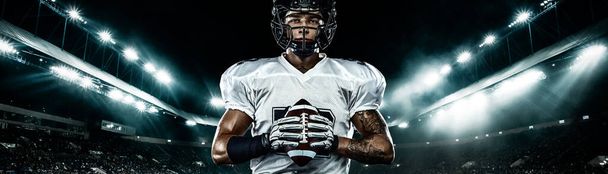 American football player, athlete sportsman in red helmet on stadium background. Sport and motivation wallpaper. Wide photo. - 写真・画像