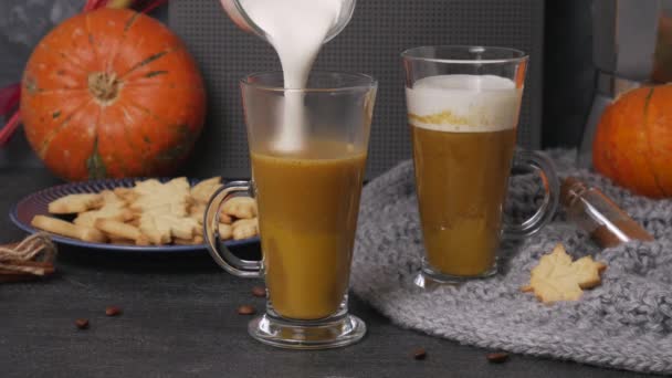 Pouring pumpkin sweet spicy latte with autumn cookies - Footage, Video