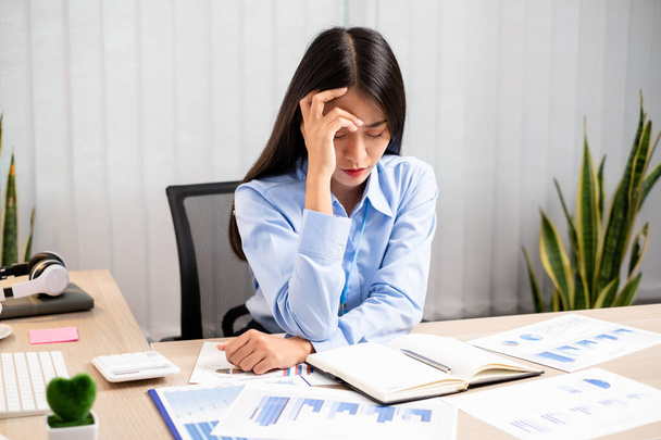 Працівниці азіатських жінок відчувають напруження, втомлення від роботи, головний біль від важкої праці під час роботи в офісі.. - Фото, зображення