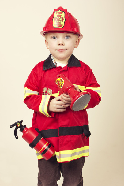 Cute Young Boy in a Fireman's Costume - Foto, afbeelding