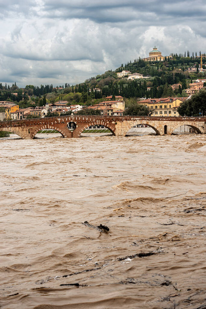 Βερόνα, Πόντε Πιέτρα (πέτρινη γέφυρα), Ι αιώνας π.Χ, και Αδίγη ποταμός σε πλημμύρα μετά από αρκετές βίαιες καταιγίδες. Μνημείο παγκόσμιας κληρονομιάς της UNESCO, Βένετο, Ιταλία, Ευρώπη - Φωτογραφία, εικόνα