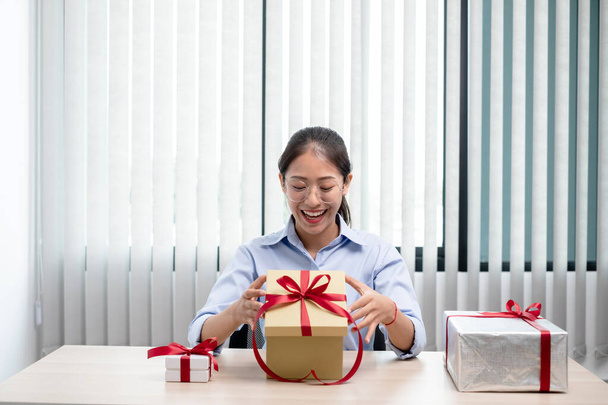 Aasialaiset naiset, jotka avaavat mielellään yllätyslaatikon, ovat hämmästyneitä jännityksestä, ilosta ja hymystä lomilla, jouluna, syntymäpäivänä tai ystävänpäivänä.. - Valokuva, kuva