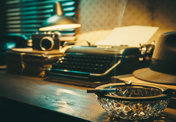 Office desk with vintage typewriter, cigarette and ashtray, 1950s film noir style - Fotografie, Obrázek