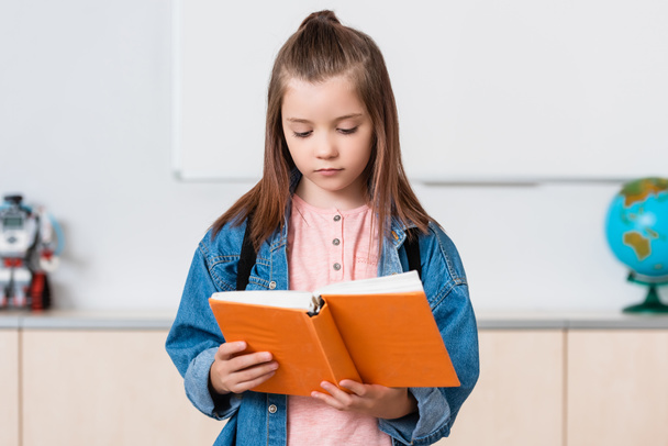 Studentessa con zaino libro di lettura nella scuola staminale   - Foto, immagini