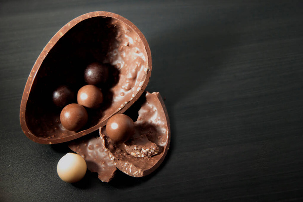 Paskalya için siyah zemin üzerinde çikolata yumurtası ve metin için kopya alanı. - Fotoğraf, Görsel