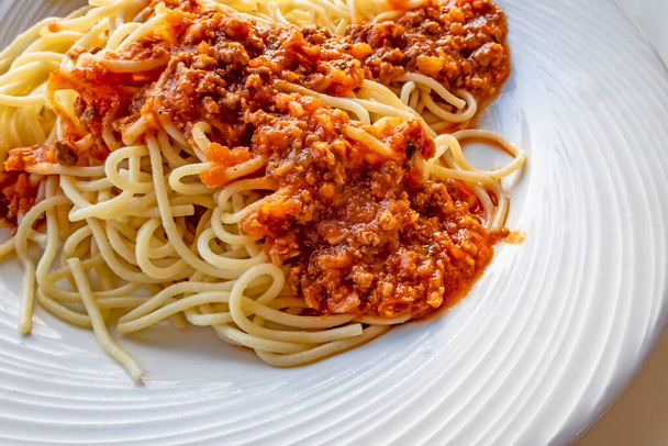 close-up spaghetti met saus op wit bord - Foto, afbeelding