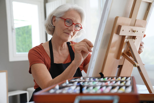 Senior woman painting on canvas - Fotó, kép