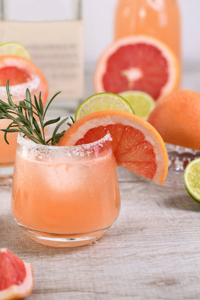  Cocktail pink Palomas tuoretta kalkkia ja rosmariinia yhdistettynä tuoreeseen greippimehuun ja tequilaan. Juhlallinen juoma on ihanteellinen brunssille, juhlille ja lomille.. - Valokuva, kuva