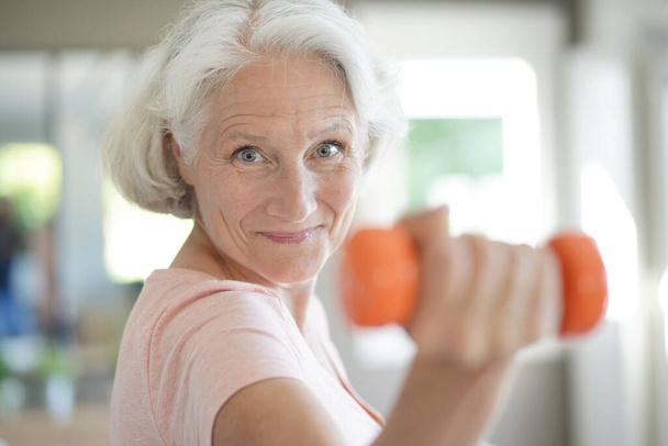 Πορτρέτο της ηλικιωμένης γυναίκας ανύψωσης αλτήρες, ασκήσεις φυσικής κατάστασης - Φωτογραφία, εικόνα