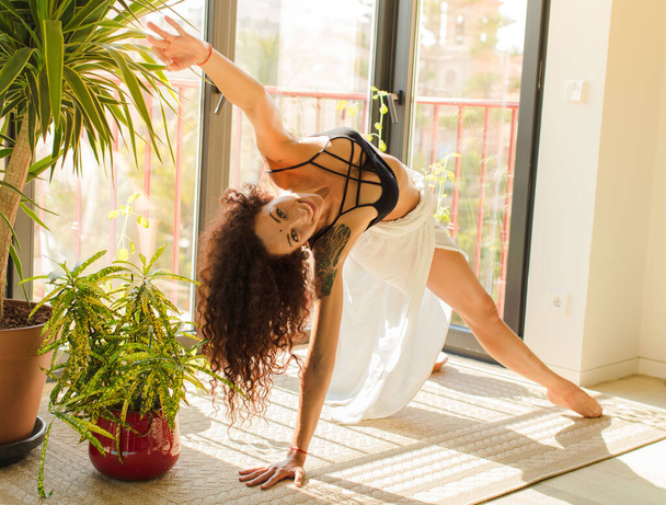 young pretty woman practising yoga indoor. relaxing and training at home - Foto, imagen