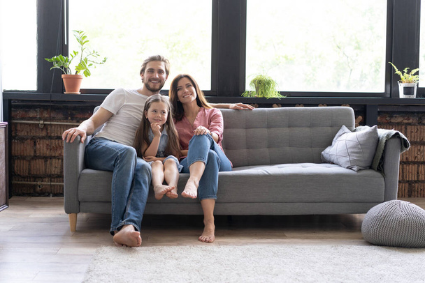 Cheerful family at home sitting in sofa. - Foto, imagen