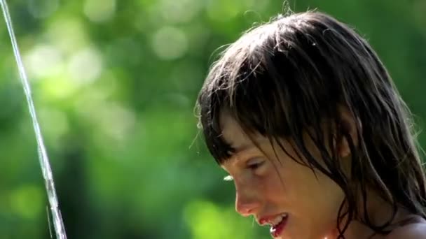 Boy playing with water in the garden,boy washing his face - Filmagem, Vídeo