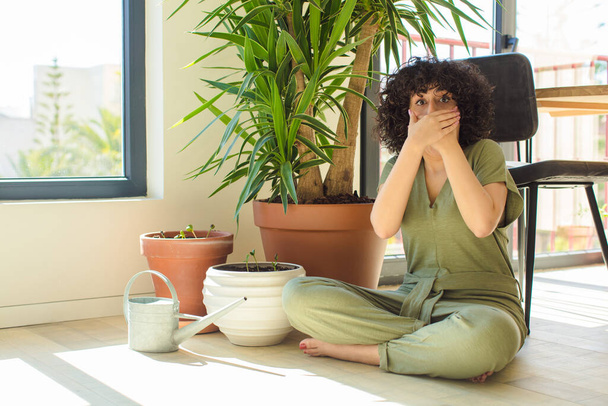 jovem mulher árabe bonita em casa, com uma lata de rega e plantas - Foto, Imagem