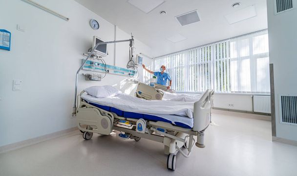 Moderne kamer in de huidige kliniek. Medisch bed en een speciaal apparaat in de moderne afdeling. Speciale moderne kamer in het ziekenhuis. - Foto, afbeelding
