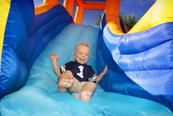Boy sliding down an inflatable Side - Photo, Image