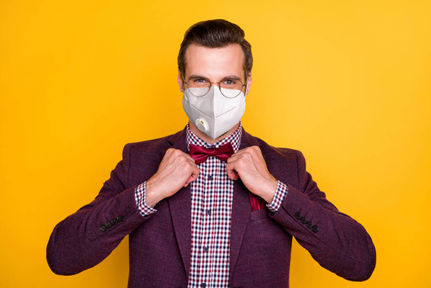 Close-up portrait of his he nice healthy chic classy imposing guy mc artist wearing n95 mask fixing bow infection prevention social distance isolated bright vivid shine vibrant yellow color background - Foto, immagini