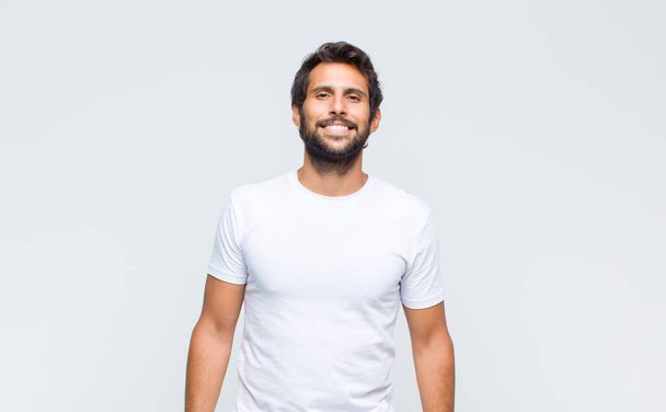 young handsome latin man posing and looking to camera against white wall - Foto, Bild
