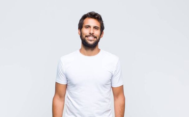 young handsome latin man posing and looking to camera against white wall - Foto, Imagem