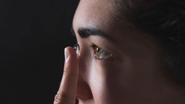 Frau setzt Kontaktlinse ins Auge - Foto, Bild