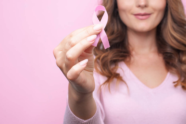 Rózsaszín pulóveres nő rózsaszín szalaggal, mellrák elleni figyelemfelkeltő kampánnyal. Emlőrák tudatosság hónapja - Fotó, kép