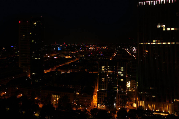 beautiful view from a height, from the window to the night modern European city of Frankfurt am Main with lights, tall skyscrapers, the concept of global business, traffic - Photo, Image