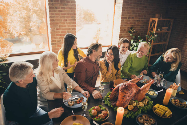 Portrait of nice attractive cheery big full family brother sister sitting around served table eating festal domestic turkey dish reunion share life stories modern loft industrial brick interior house - Photo, Image