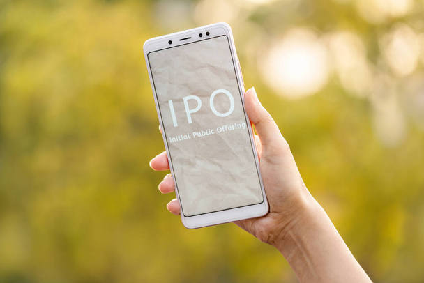 当初の公募コンセプト。コピースペースのある屋外の背景に画面に表示される、携帯電話&ショーIPOを保持する若い女性の手。LIC IPO. - 写真・画像