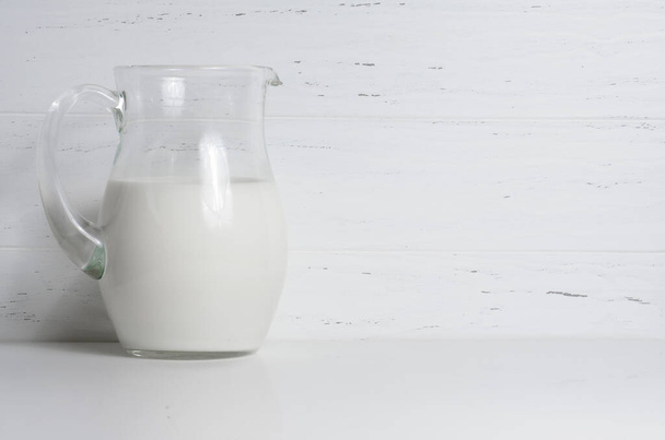 Milk in a glass jug. The concept of natural and healthy food. White background. Copy space - Фото, зображення