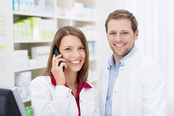 Smiling pharmacist chatting on the phone - 写真・画像
