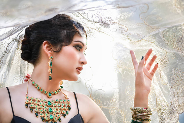 Retrato de hermosa joven asiática tailandesa con negro y oro vestido tradicional de la India. - Foto, imagen