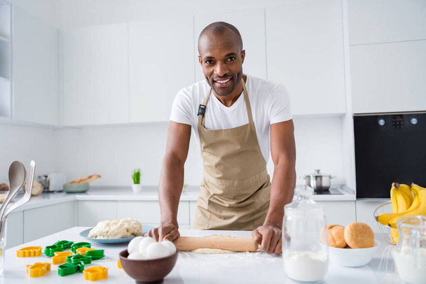 Portrait of his he nice attractive cheerful guy making fresh handmade bread pizza pie rolling dough duty chores household hobby free time in modern light white interior house kitchen - Fotó, kép