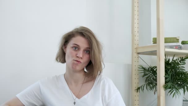 Giovane caucasica insoddisfatta donna irritata siede a casa, inizia a ridere - Filmati, video