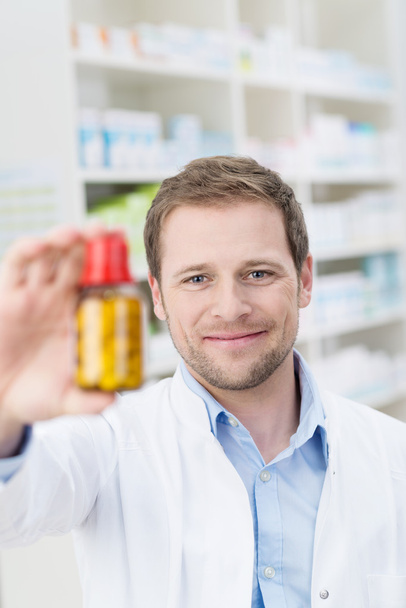 Pharmacist displaying a bottle of pills - Foto, afbeelding